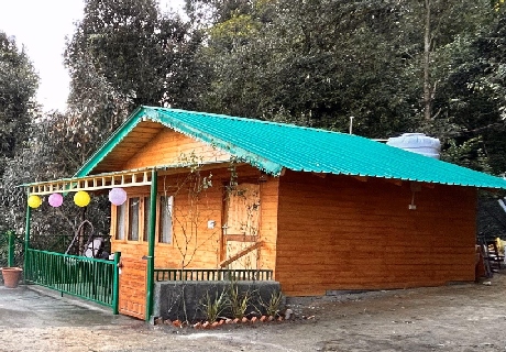 a wooden house with a green roof